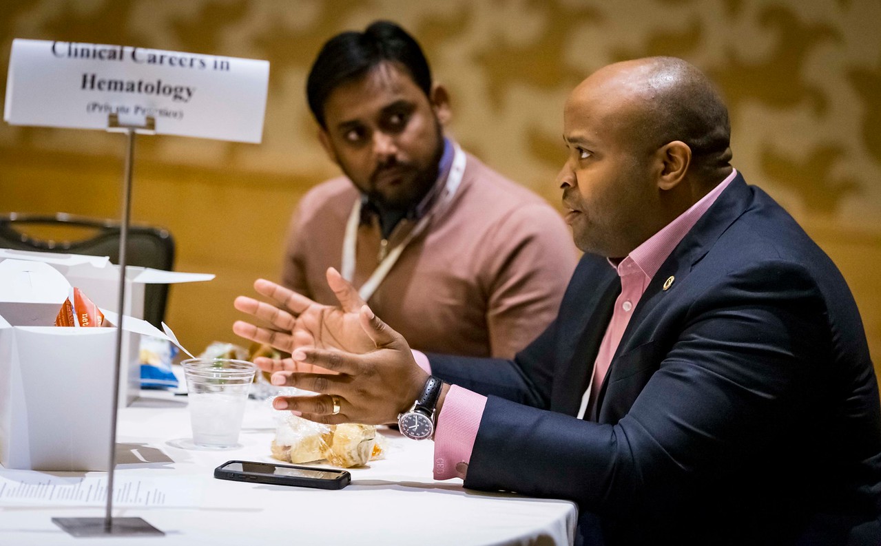 An expert speaks to a trainee during a career development lunch session.