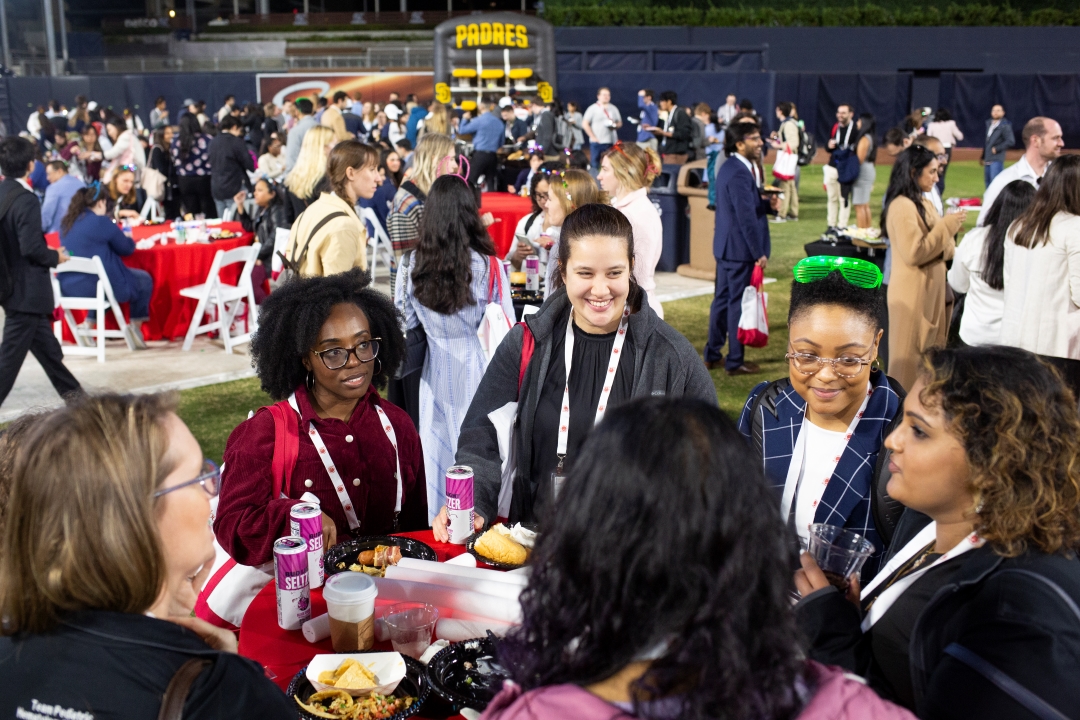 Trainees chat around a table at the welcome reception.