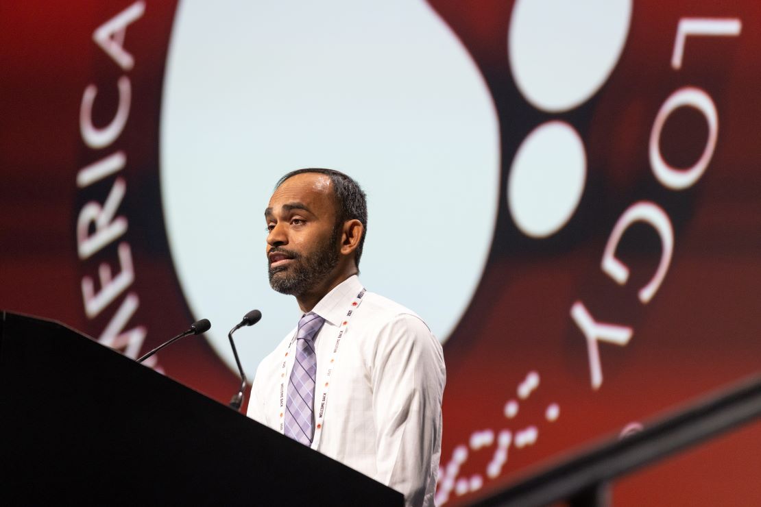 A person gives a presentation at a podium during the 2024 ASH Annual Meeting