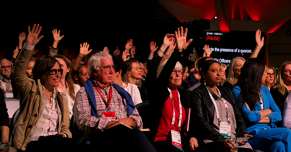 A group of people raised their hands at a lecture during the annual meeting